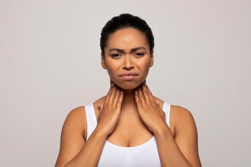 Female patient holding neck with swollen tonsils