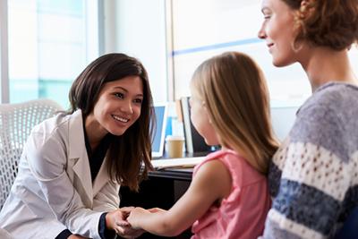 Pediatrician meeting little girl and mom for routine child care