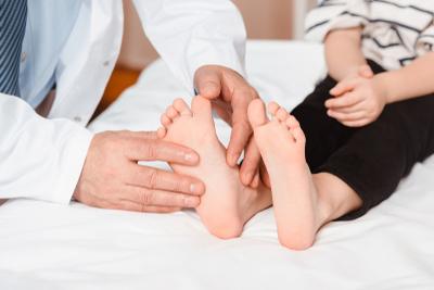 Doctor checking the foot condition of a child.